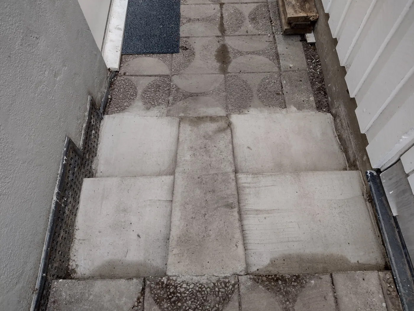 Nygjuten betonggång längs en husvägg