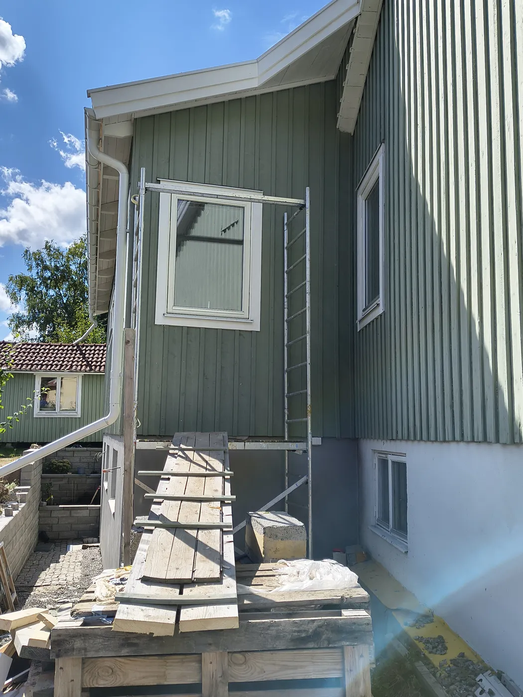 Nytt fönster monterat i den grönmålade träfasaden
