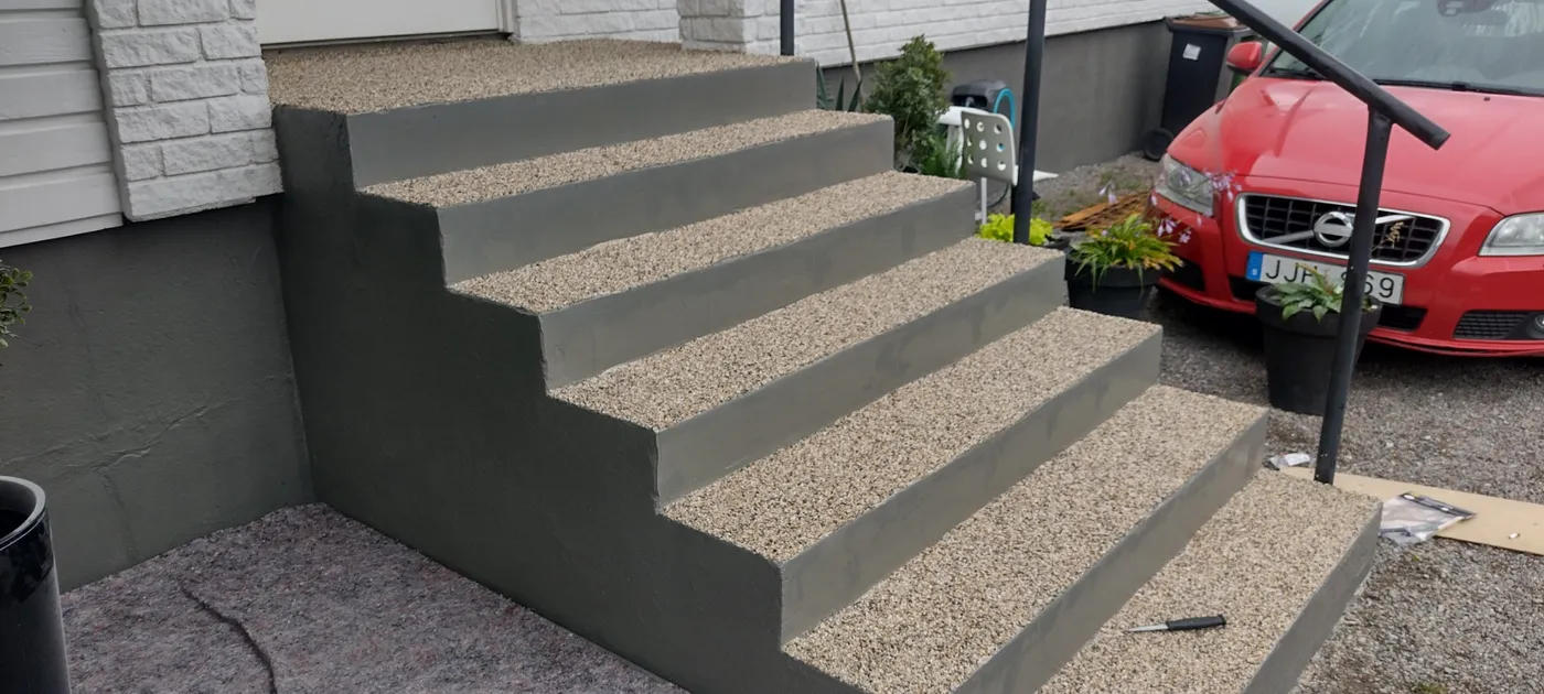 Färdig betongtrappa med tvättade stensteg och målade sidor