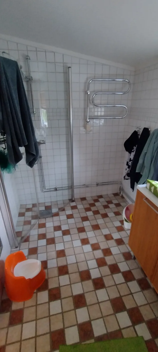 Badrum med grön kakelvägg före arbetet