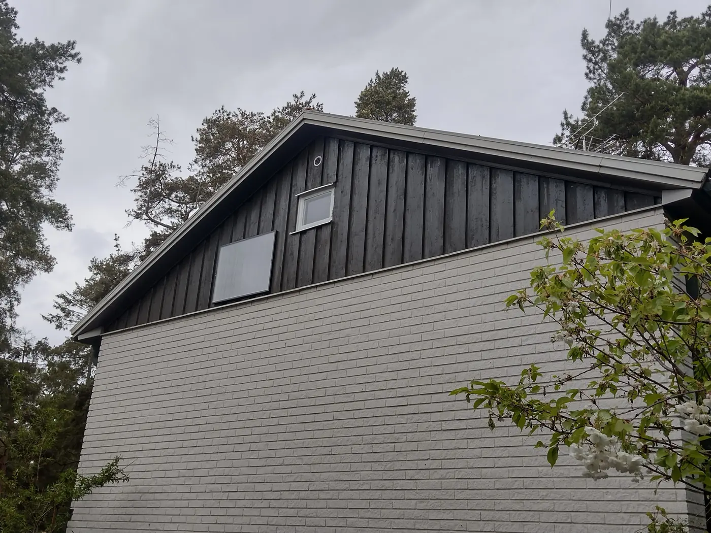 Samma gavel med ny mörk stående panel efter fasadbytet