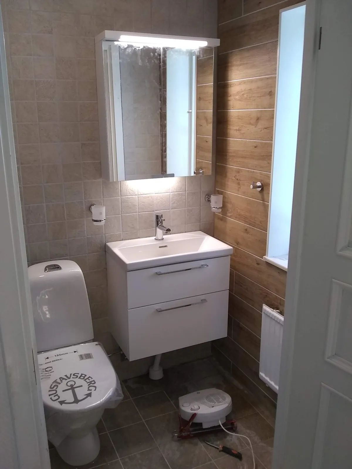 Badrumsrenovering med träimiterande kakel i Haninge, bild 1 av 2