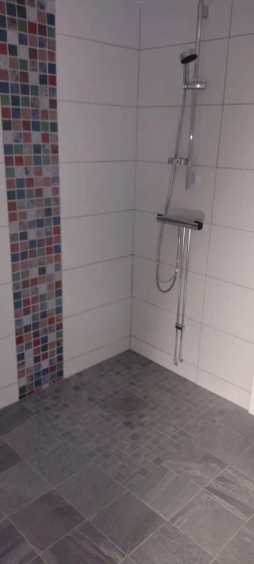 Badrumsrenovering med mosaikrand utförd av Robert’s Hantverks Service