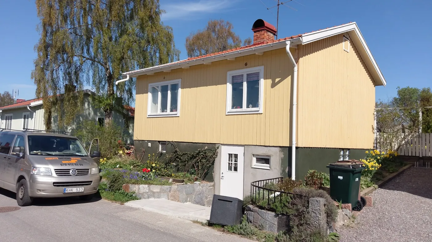 Fasaden färdigmålad i gult, sedd från gatan