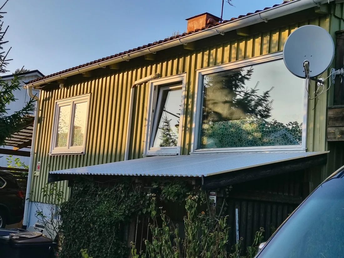 Färdigmålad fasad med gul överdel och grön nederdel under tegeltak